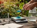 Préparation du **dosage bouillie bordelaise pour arbres fruitiers**. Une balance de précision pèse la poudre bleue, à côté d'un carnet et d'une carafe d'eau.